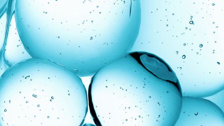 A close up of a series of blue watery spheres against a white background.