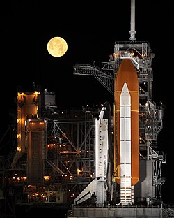 Space Shuttle Discovery under a full moon